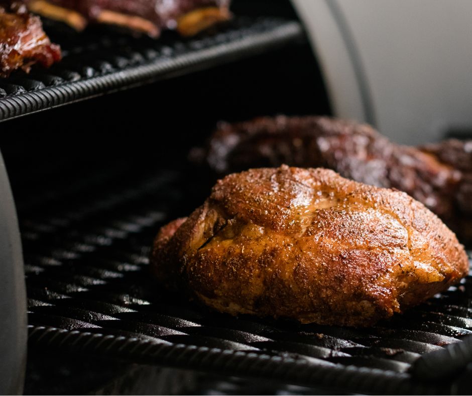Smoked chicken thighs on a smoker grate.