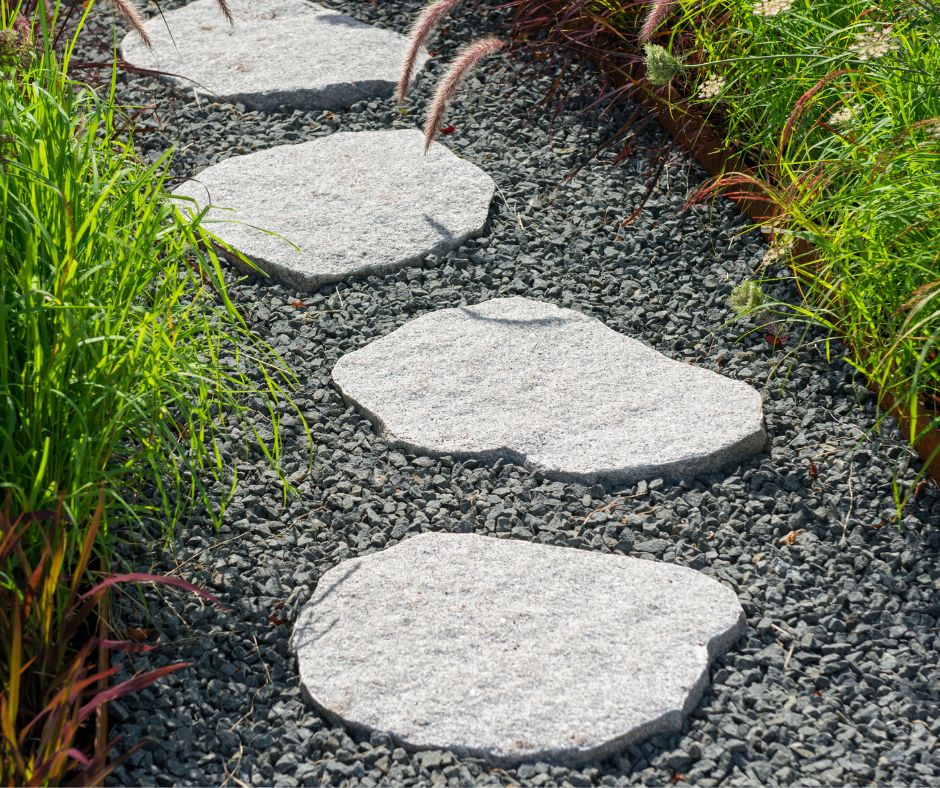 Light grey stepping stones nestled in dark grey gravel create an easy diy garden path.