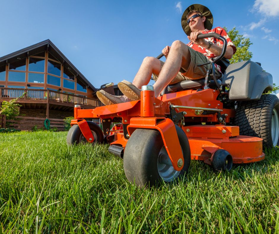 A person mowing a lawn on a riding mower.