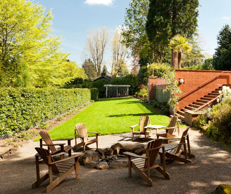 A backyard patio fire pit with privacy hedges.