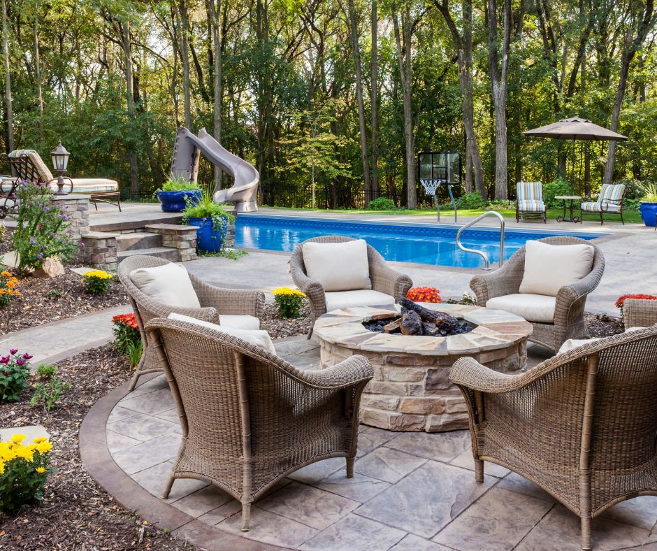 A private backyard pool with slide and fire pit seating area.