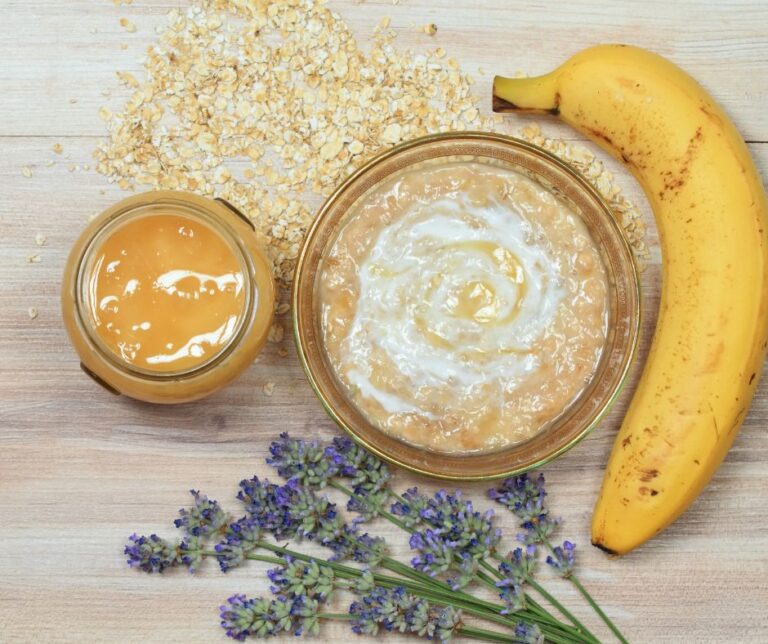 A collection of ingredients for a homemade face mask. Including oats, yogurt, lavender, and a banana.