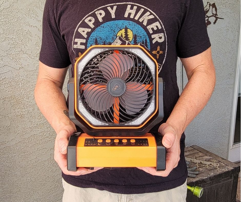 A person hold a battery powered fan.
