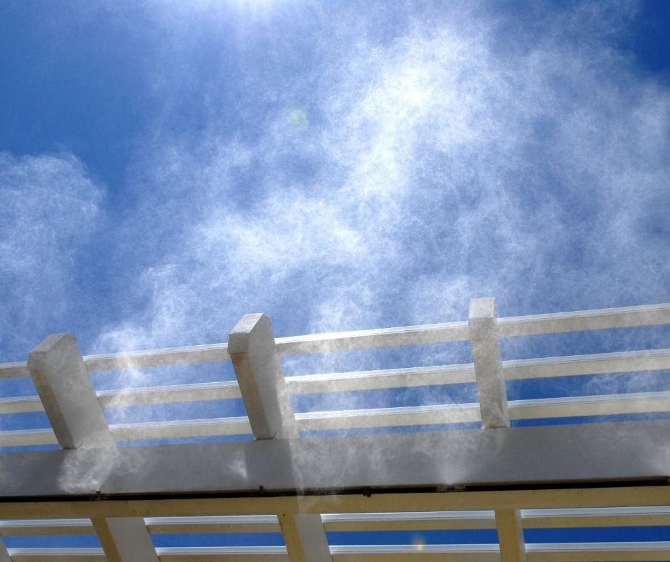 Mist falling from a patio misting system.