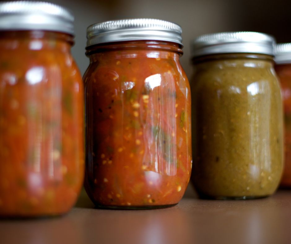 A variety of red and green home canned salsas.