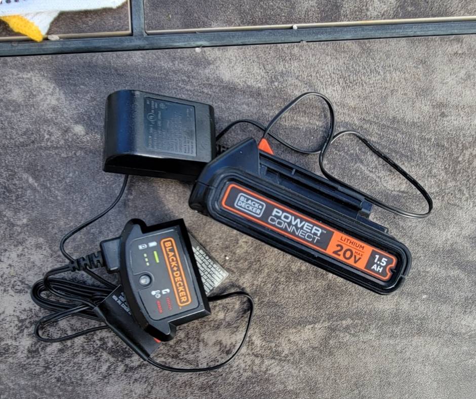 Black and orange battery pack and charger for a cordless hedge trimmer.