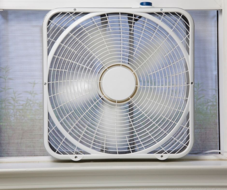 A white box fan in a window.