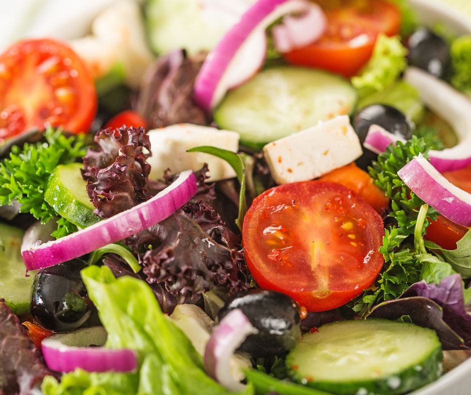 A fresh salad with fresh veggie topping including tomatoes.