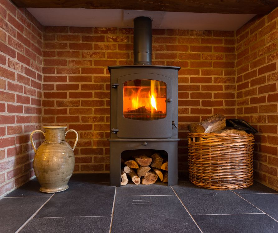 Cast iron wood stove in a brick fireplace.