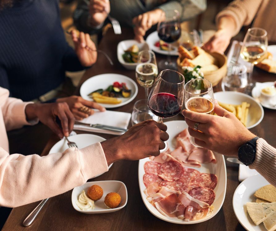 A number of guests at a table toasting before a meal.