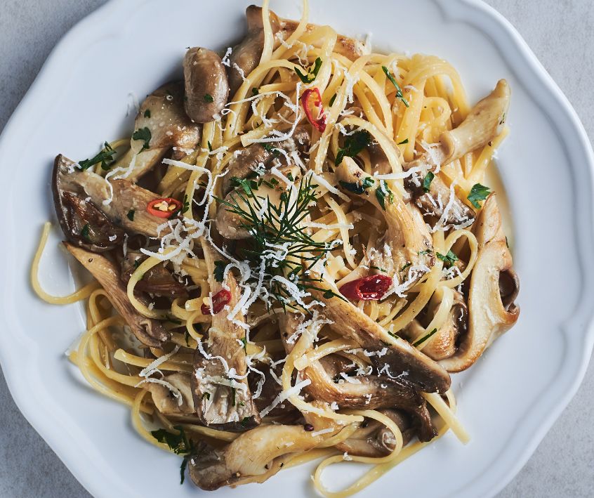 A plate of creamy mushroom and veggie pasta.