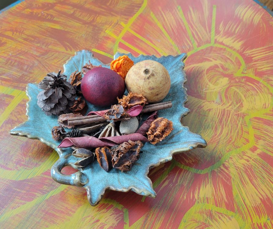Potpourri displayed on a brass leave on a table.