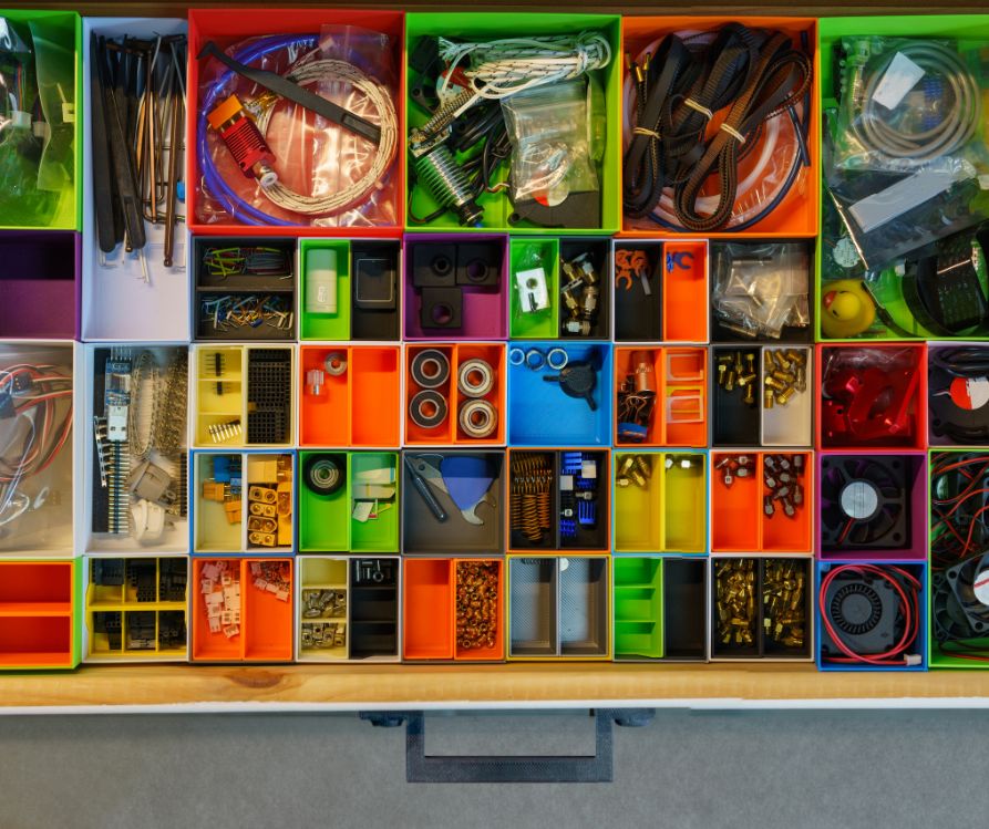A rainbow colored compartmentalized drawer for organizing small items.