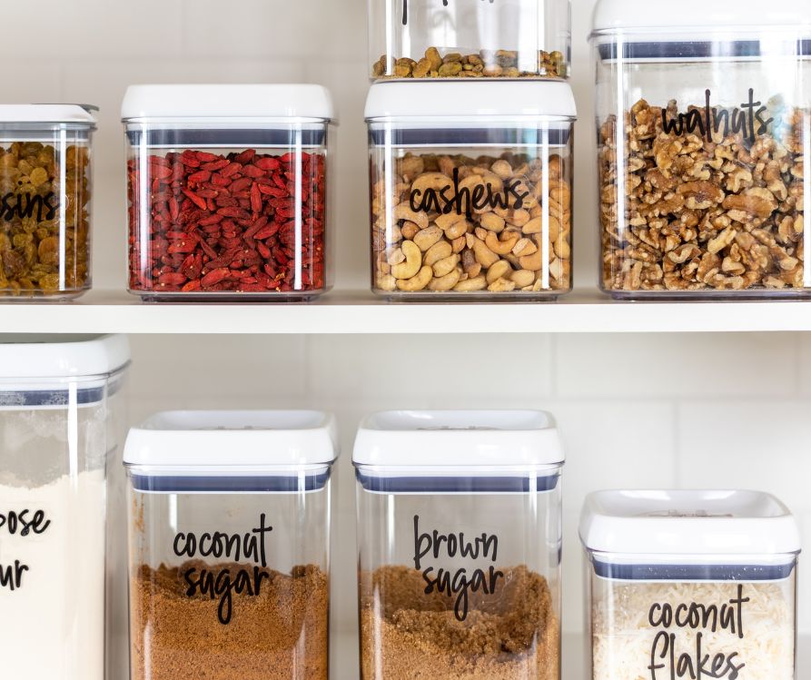 To shelves of clearly labeled food items in clear plastic containers.