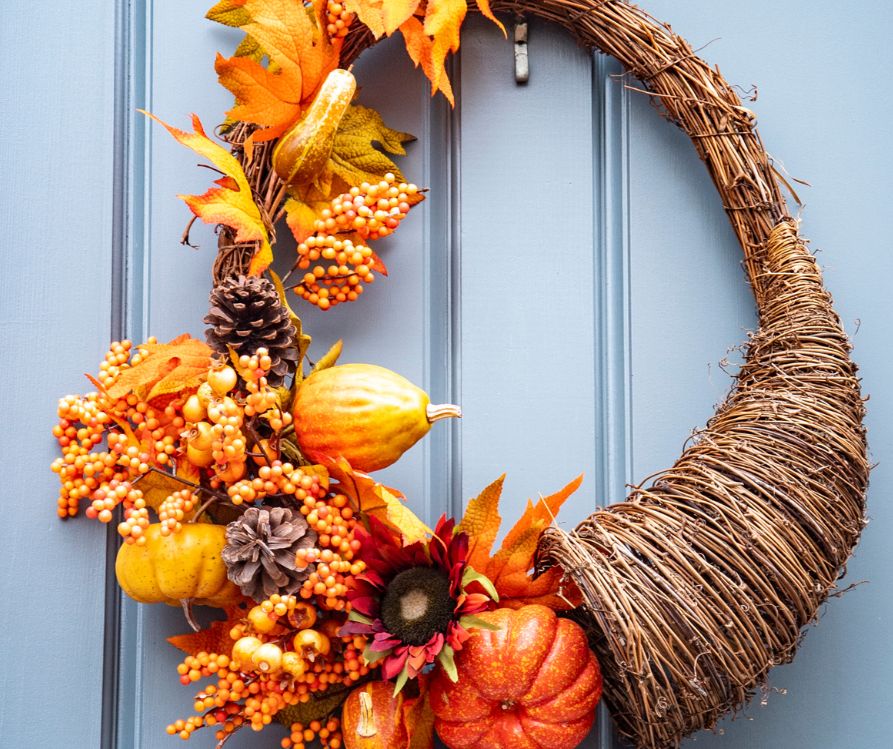 Harvest Horn door hanger in fall motif of flowers and squash.