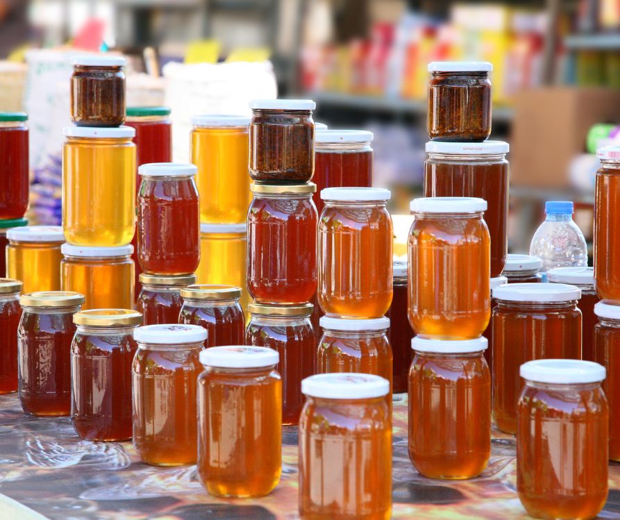 Jars local honey on a table at a fair.