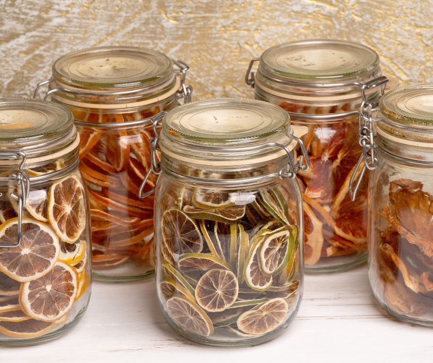 Jars of dried sliced citrus organized by variety.