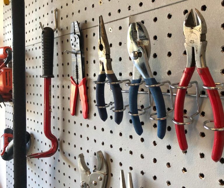 Tools organized on peg board on a garage wall.