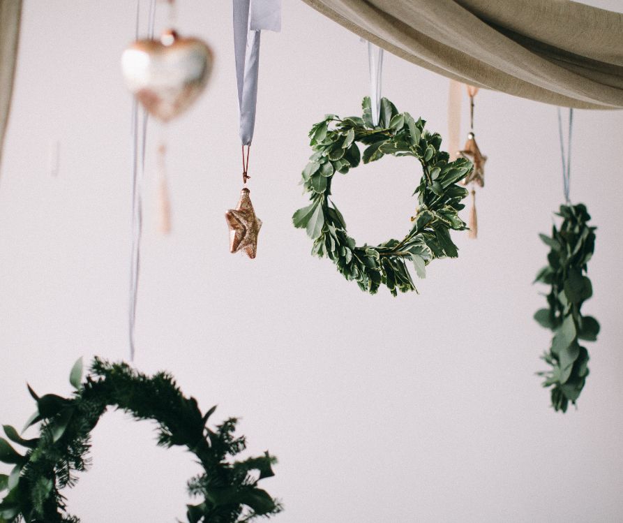 Small delicate holiday ornaments hanging from ribbons.
