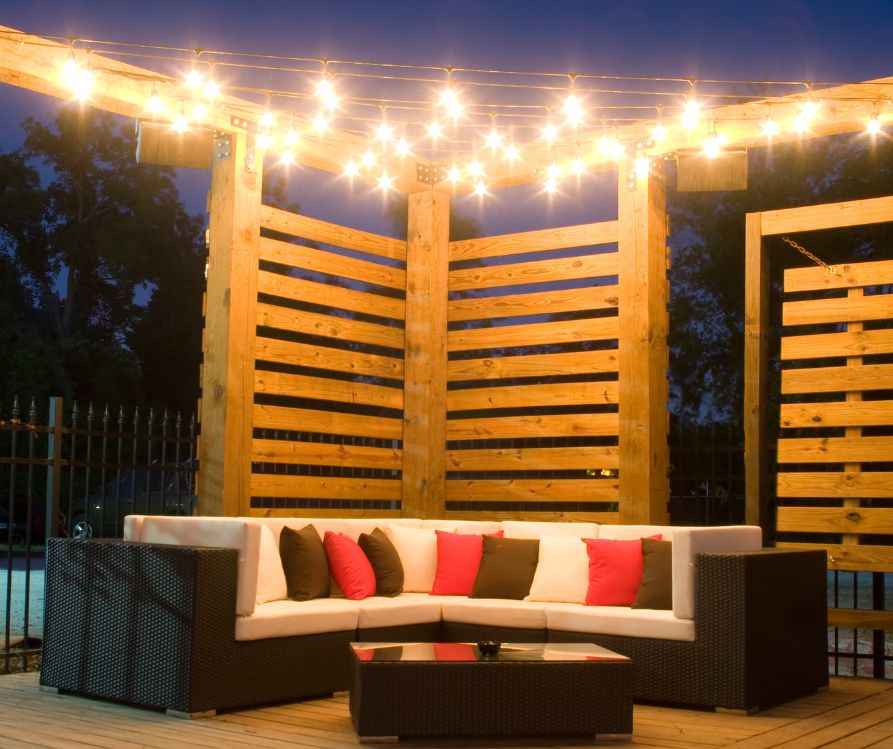 Wooden Privacy Panels around an outdoor couch and string lights.