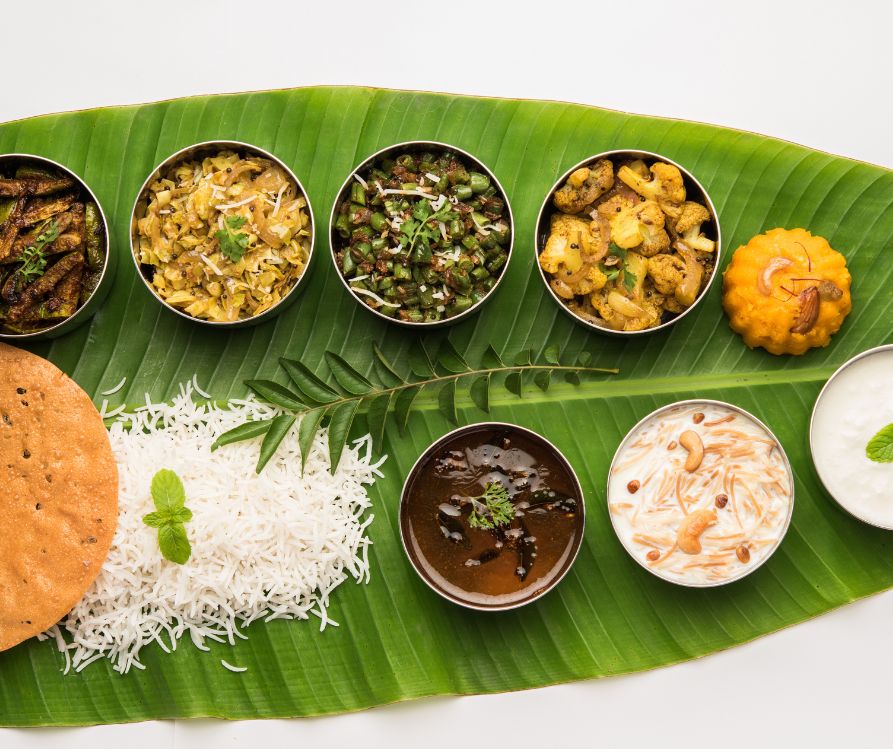 South Indian style lunch or dinner meal or food served with a selection of recipes over banana leaf