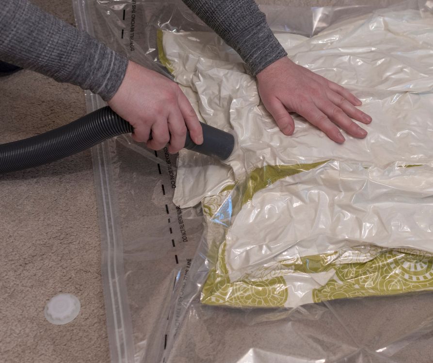 A person vacuum sealing storage bags.
