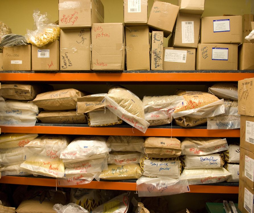 A pantry full of bulk food clearly labeled in the original container or in cardboard boxes.