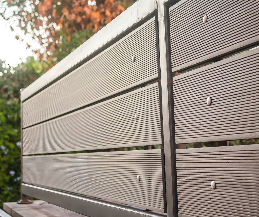 A dark grey metal privacy screen made with three slats.