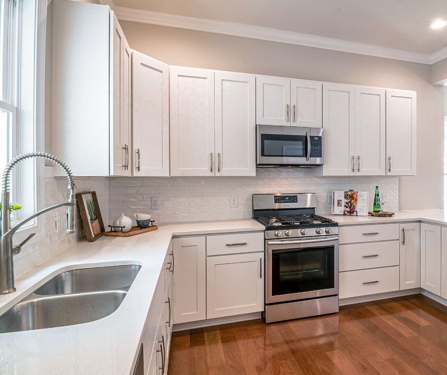 Modern updated kitchen with white cabinets and stainless steel appliances.