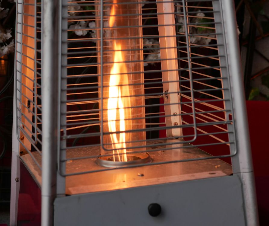 An orange flame in a metal propane patio heater.