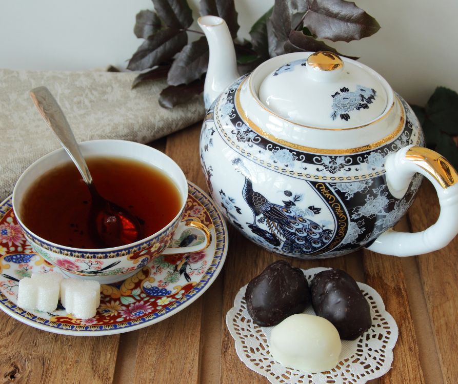 Blue and white porcelain tea set with a serving of chocolate sweets and heart shaped sugar cubes.