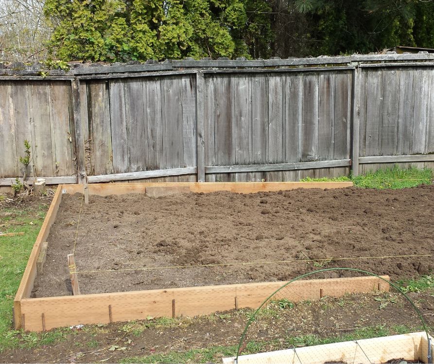 A wood retaining wall installed to create a level greenhouse foundation.