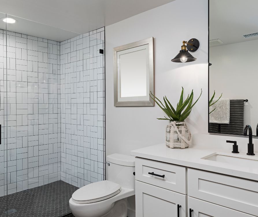 Modern bathroom with white tile and cabinets.