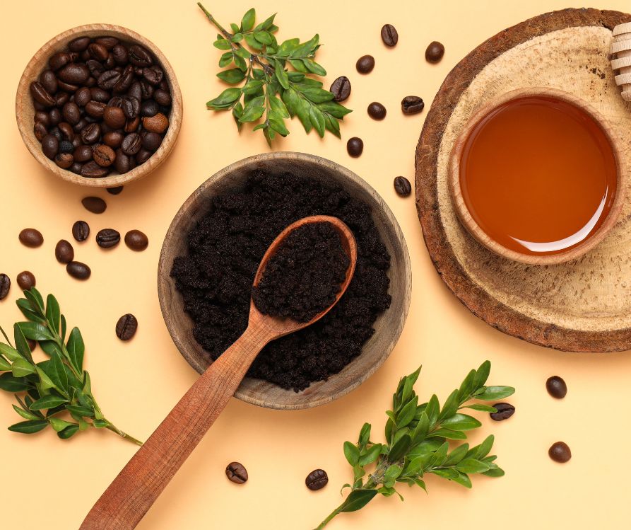 Coffee scrub for the body, in a wooden plate with a spoon, on a wooden table.