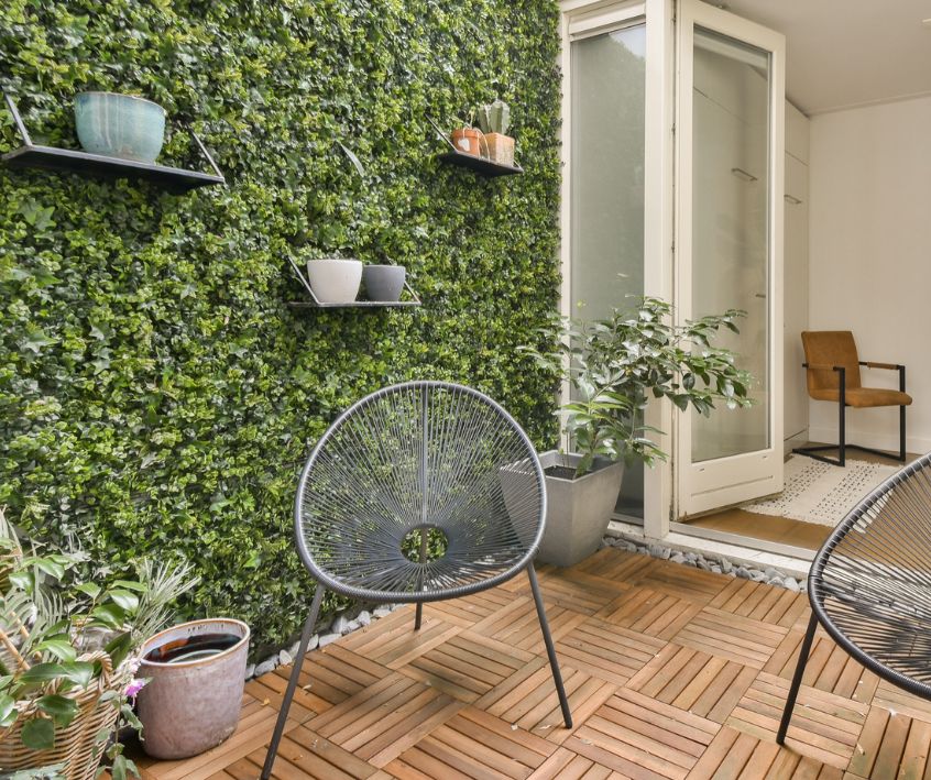 Quiet patio seating area with a green wall.