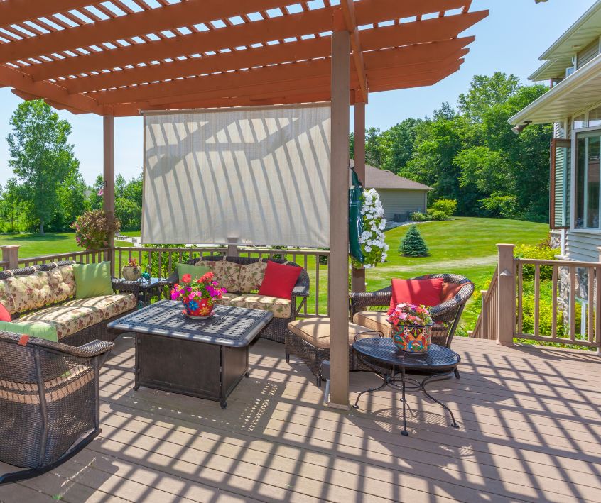 Inviting backyard patio deck with pergola and outdoor curtain blocking the neighbors view.