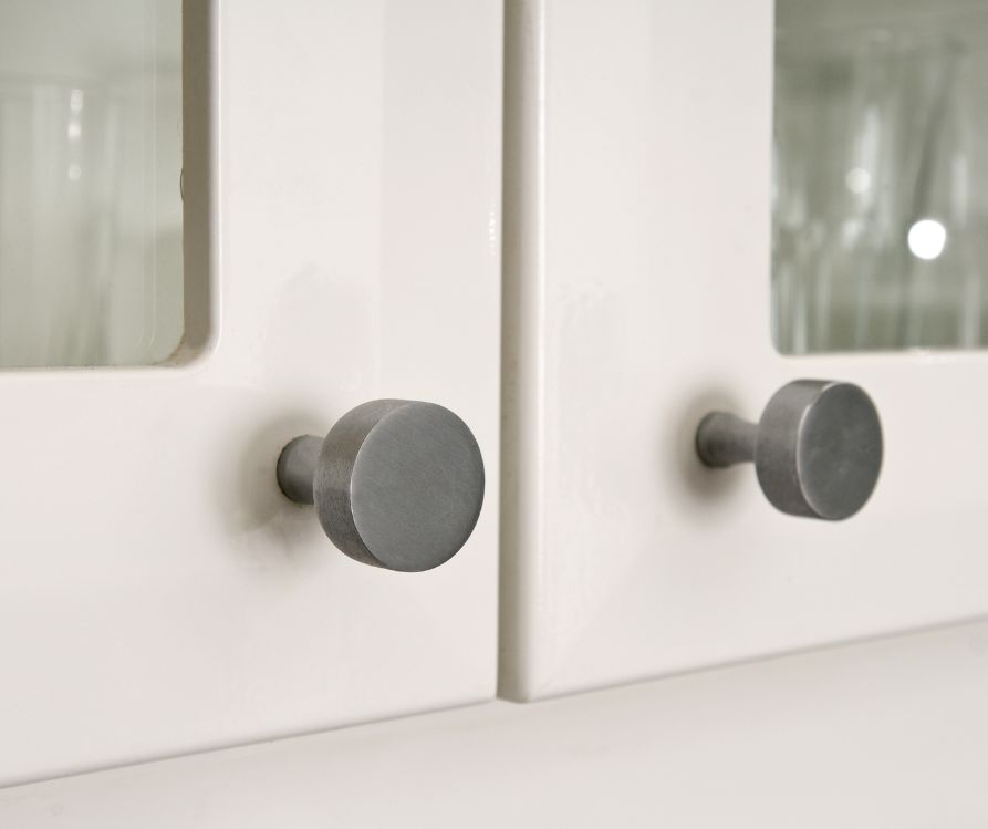 Brushed modern knobs on kitchen cabinets.