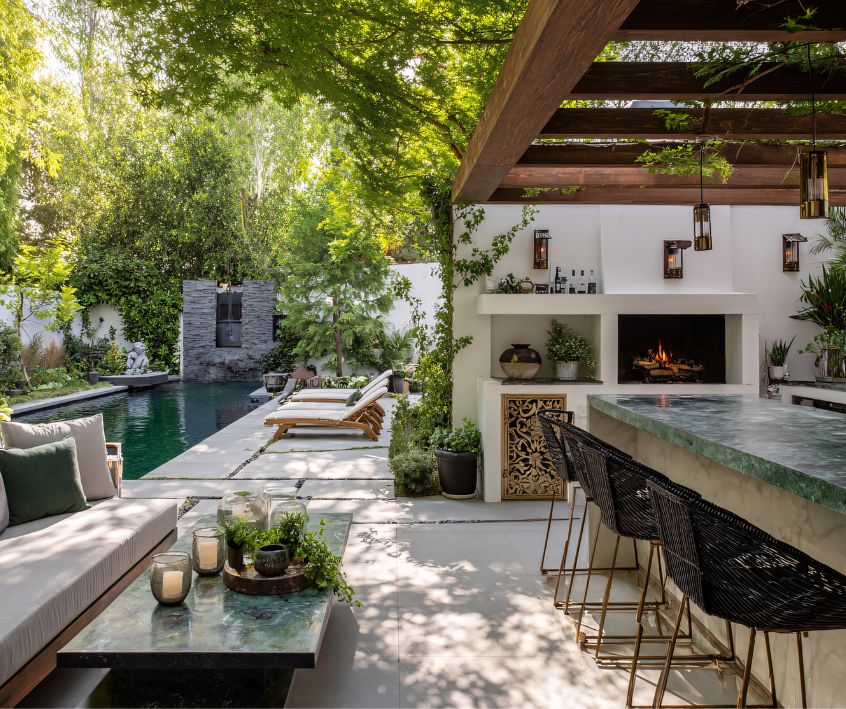 Mediterranean-style villa patio with a large outdoor kitchen, pool, and seating.