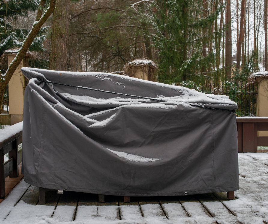Patio furniture Cover protecting outdoor furniture from snow.