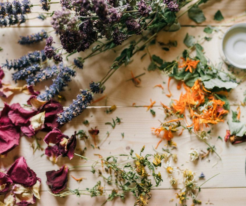 Dried rose, lavender, chamomile, and calendula flowers on a table.