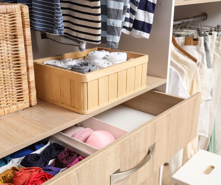 Open Drawer with Organized Clothes in Wardrobe.
