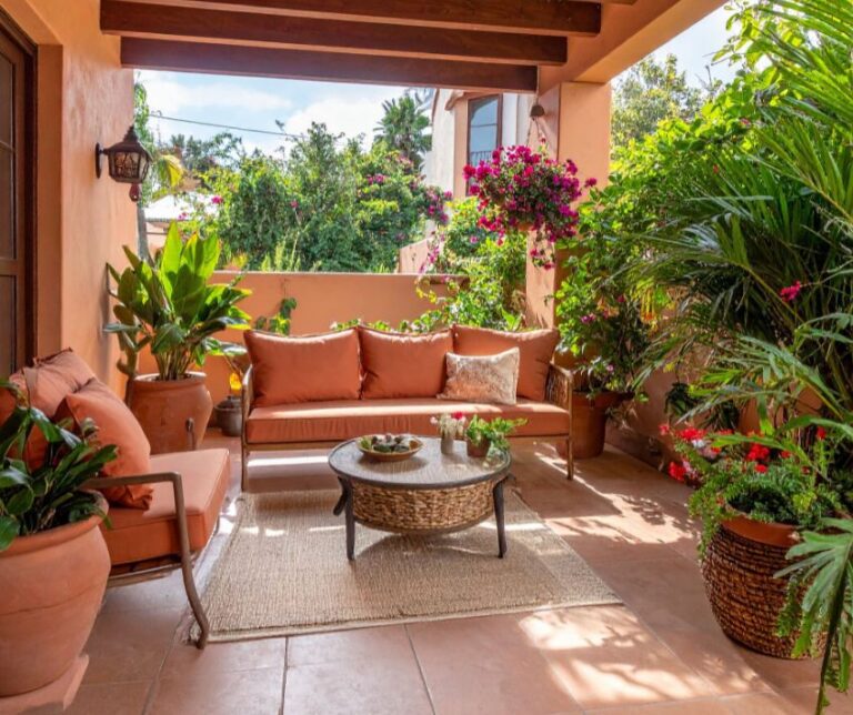 Cozy terrace with outdoor seating area and plants for privacy.