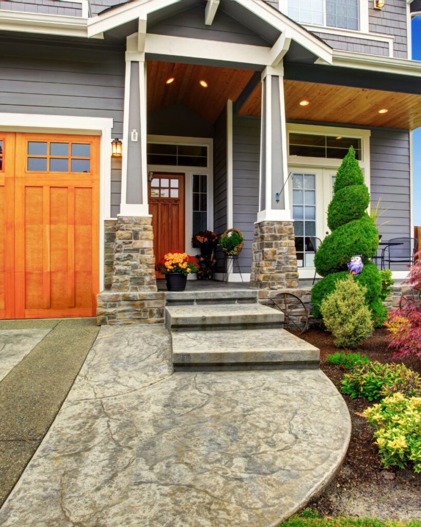 House entryway featuring a textured walkway and mulched landscaping.