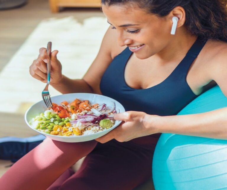 A woman eating a vegetable filled post workout meal
