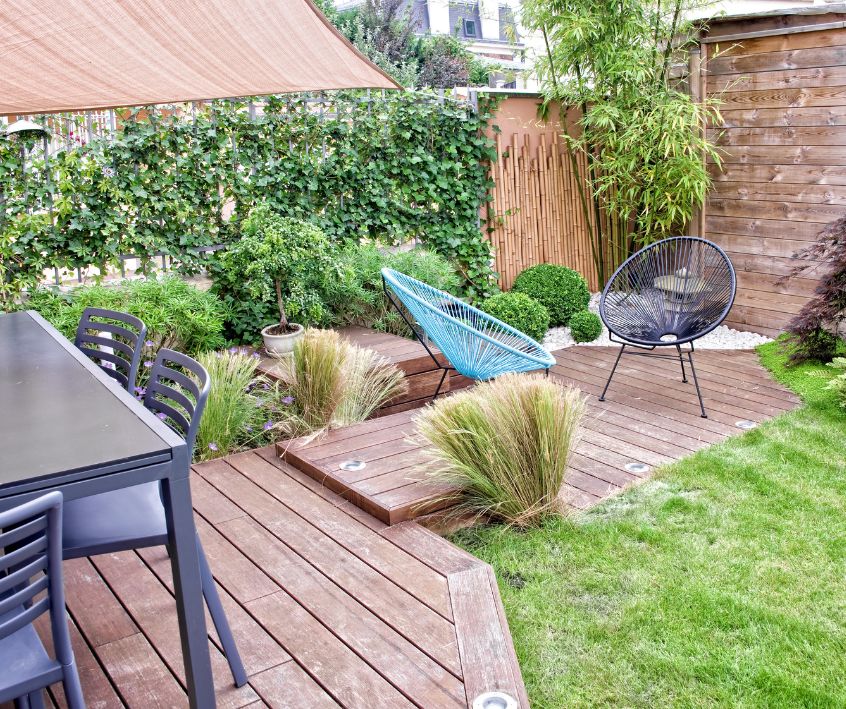 Private terraced deck seating areas, lush green garden, shielded by privacy screens.