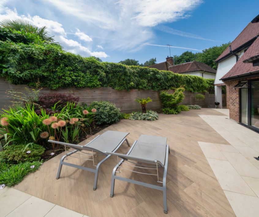 A patio and garden with loungers on sunny, summer day