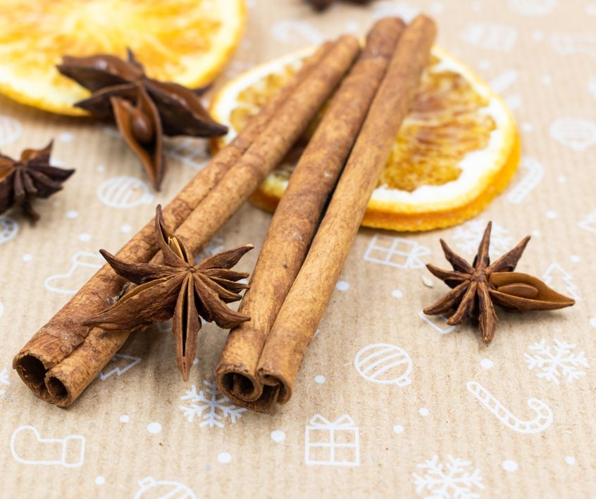 Dried orange slices, star anise and cinnamon sticks on a table.