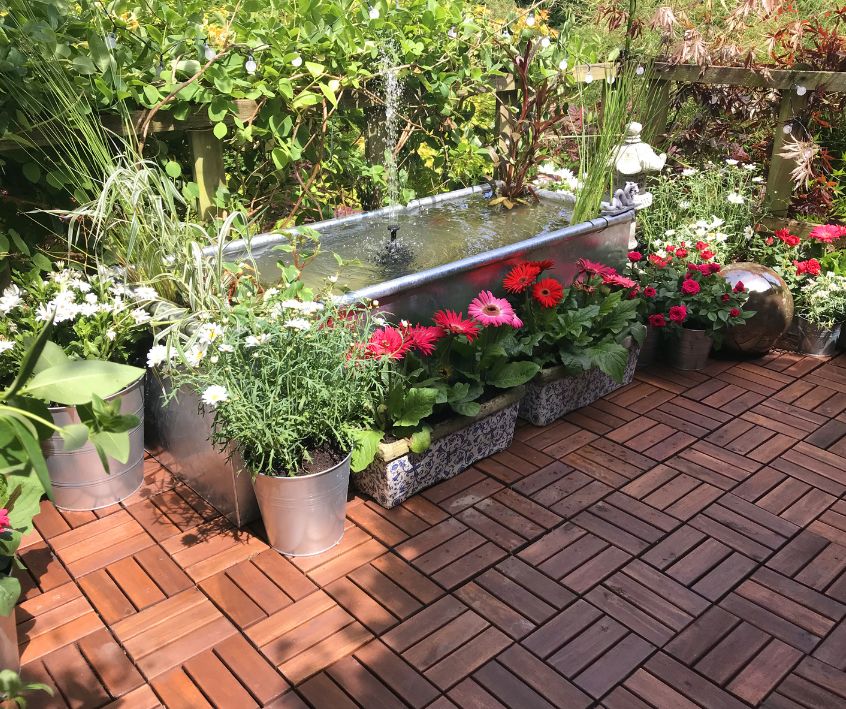 Raised garden pond in metal zinc agricultural galvanized cattle trough water feature.