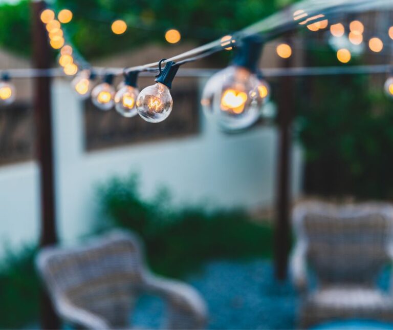 Patio string lights above a backyard sitting area.