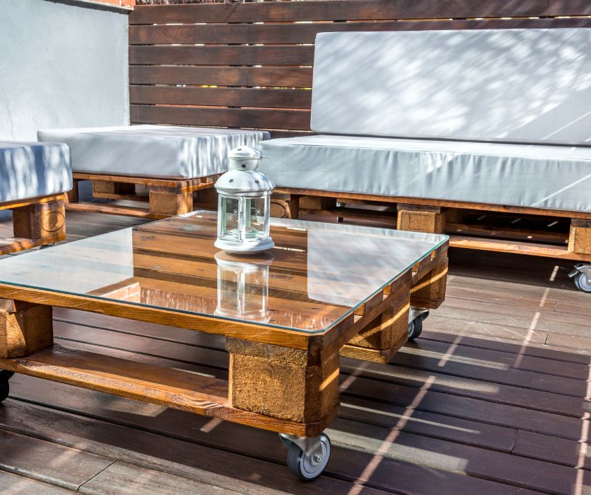A pallet patio furniture set with comfy grey cushions.